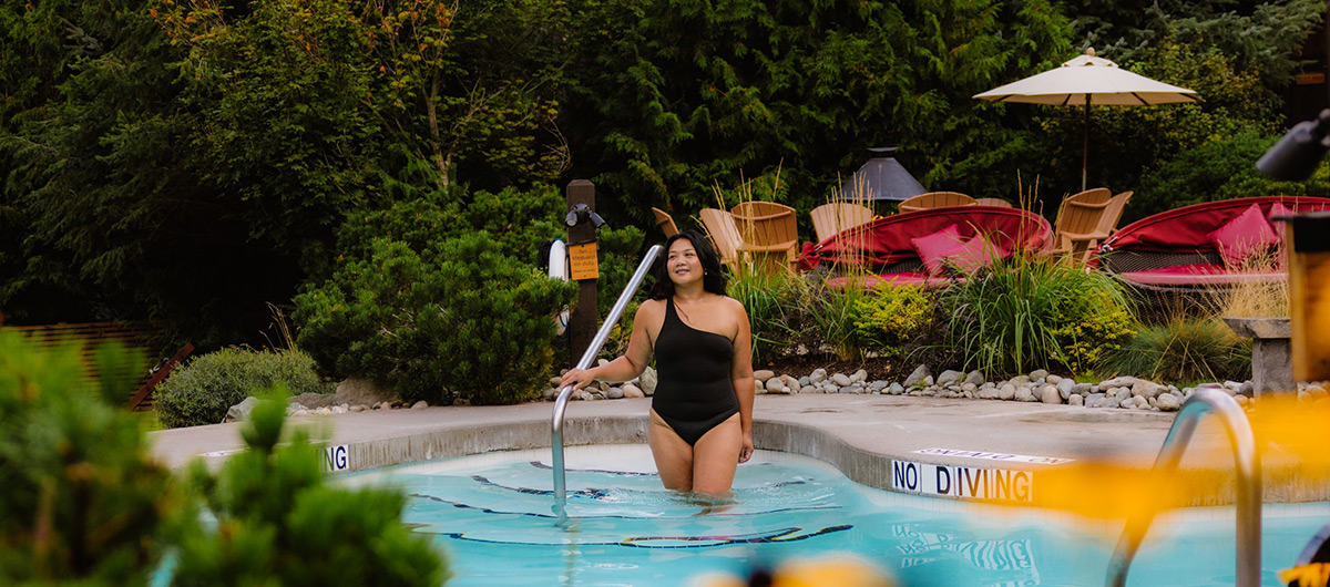Woman looking relaxed and happy entering a spa hot tub